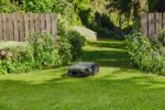 STIHL iMOW 7 EVO cortando el césped en un amplio jardín – Automower eficiente y silencioso, con conexión inteligente para un mantenimiento sin complicaciones